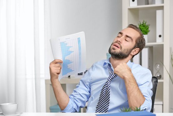 picture of man fanning himself with stack of papers